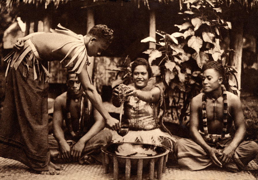 Kava ('ava) makers (aumaga) of Samoa. A woman seated between two men with the round tanoa (or laulau) wooden bowl in front. Standing is a third man, distributor of the 'ava, holding the coconut shell cup (tauau) used for distributing the beverage.